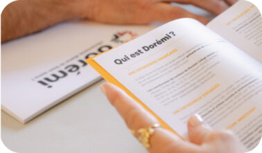 brochure Dorémi une main tenant une brochure dorémi où il est indiqué "qui est Dorémi"
